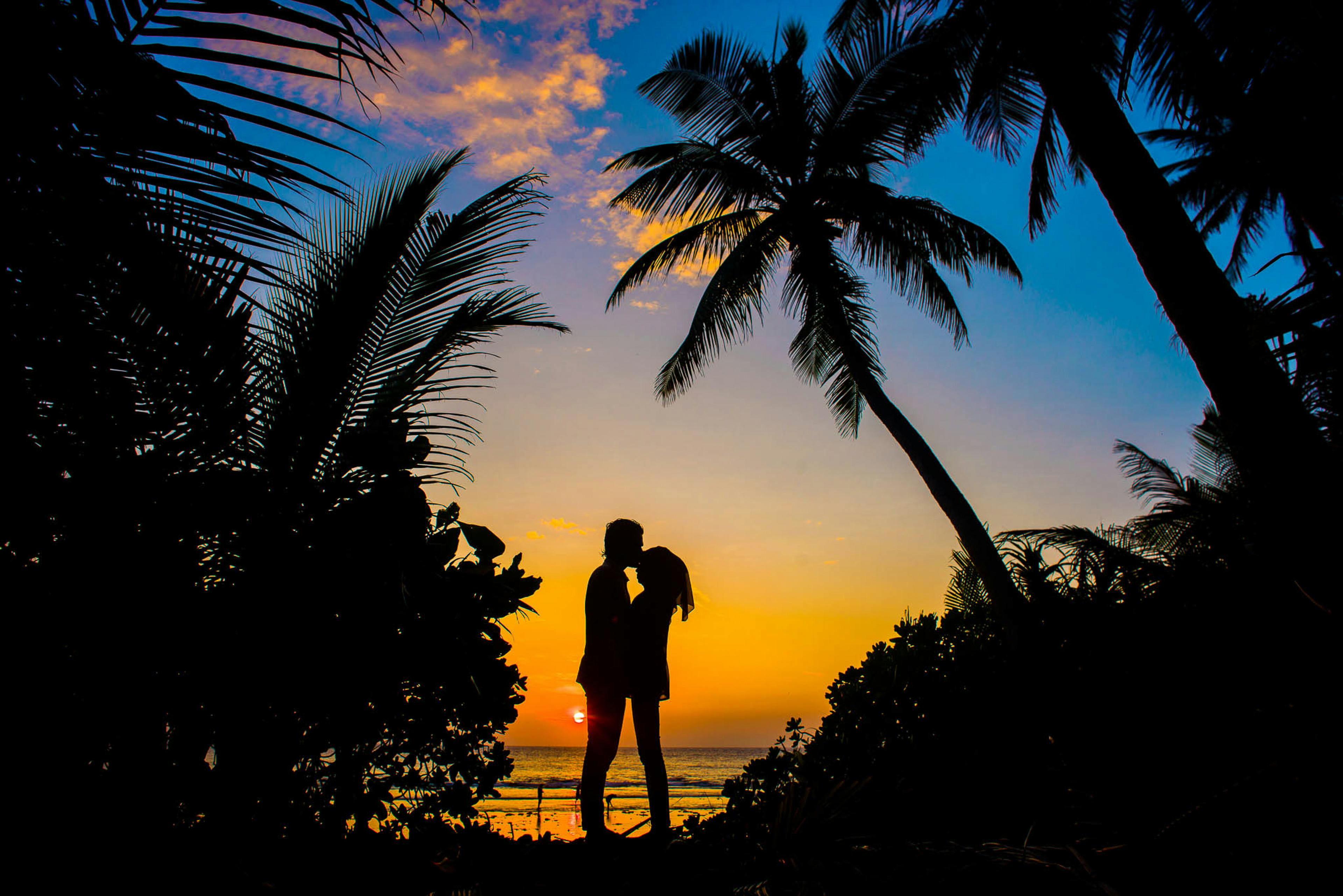 couple with sunset behind them in paradise